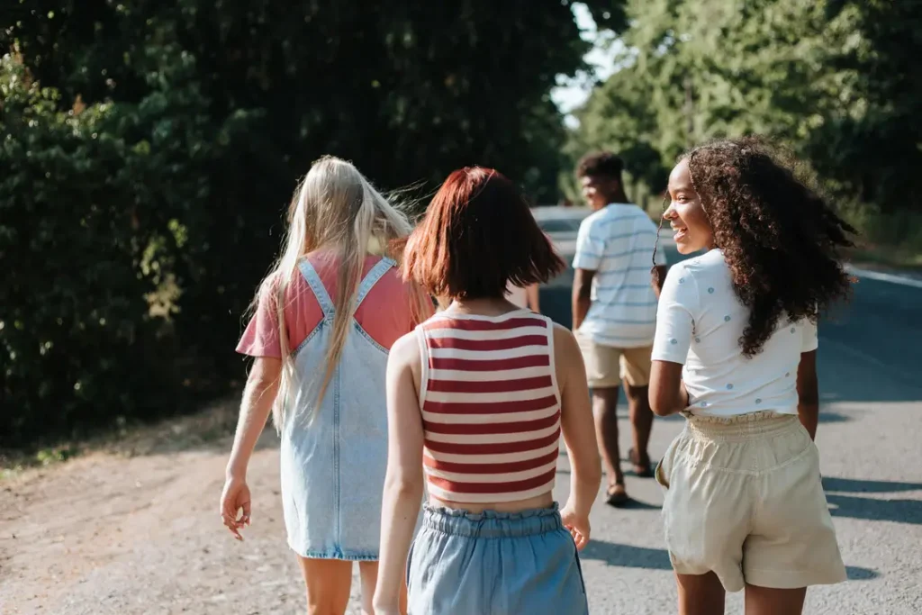 Group of four teens walking down a road